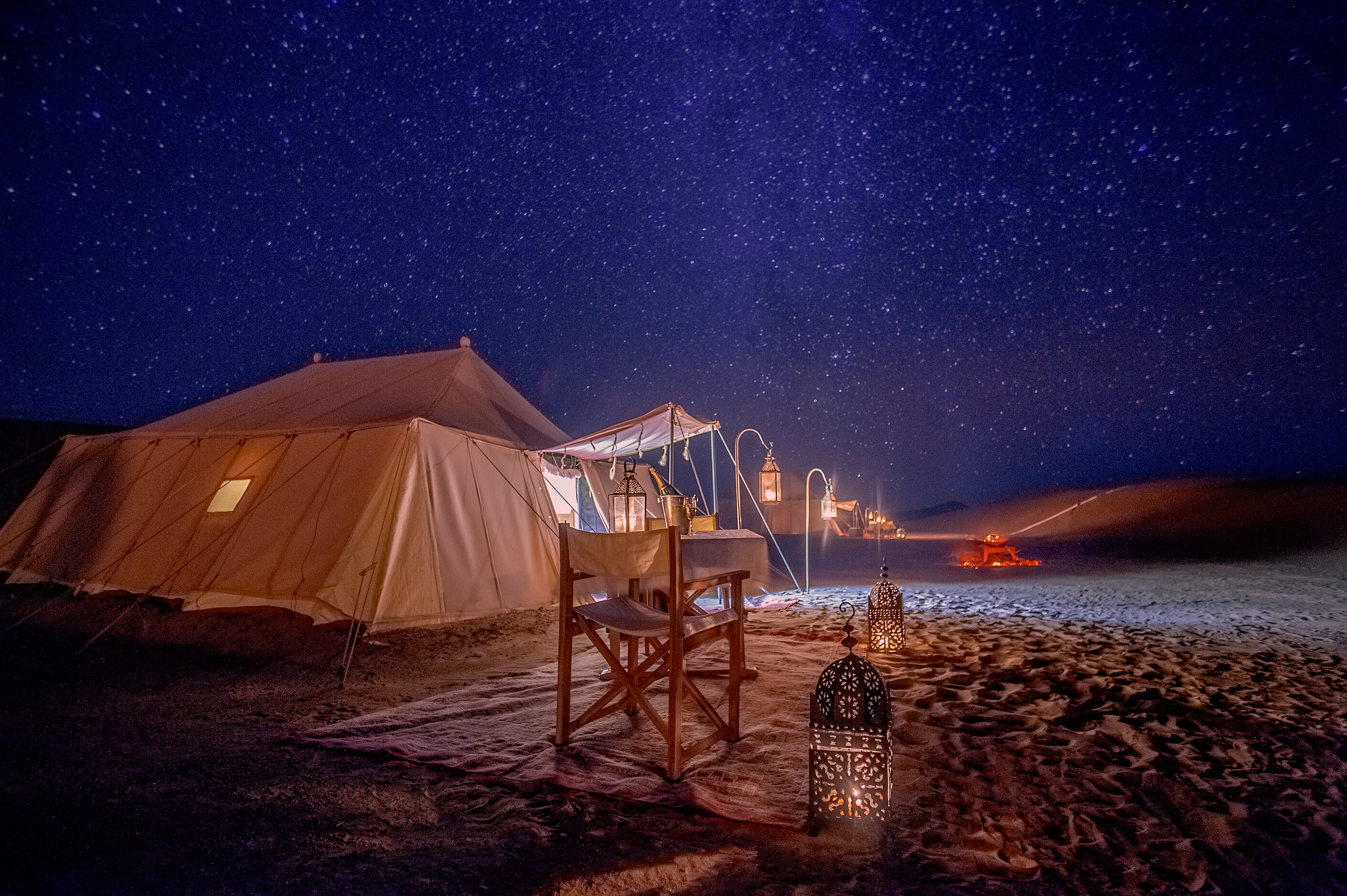 Glamping tents under starry night sky somewhere in the wilderness. 